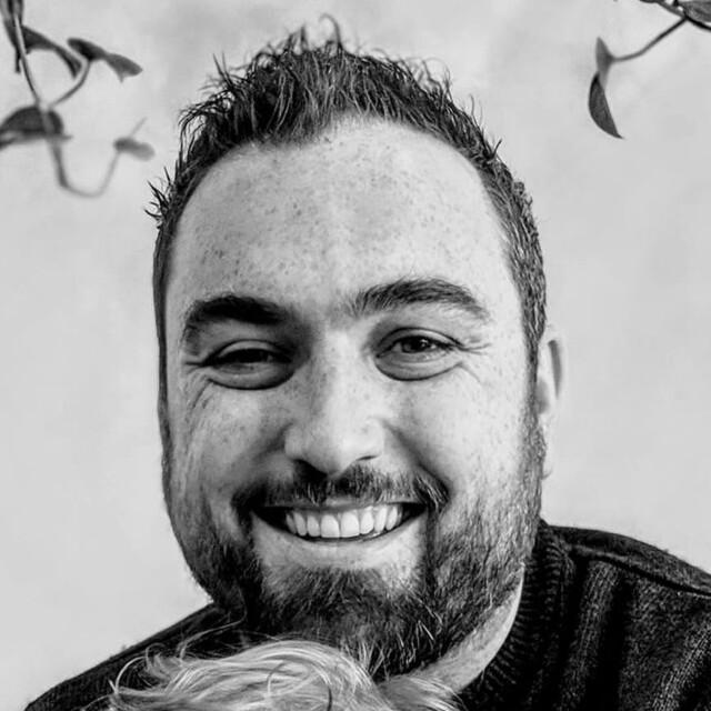 Dan Napoleoni smiling, black and white headshot